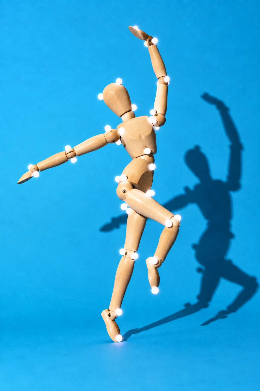 A wooden mannequin dancing, dotted with motion-capture markers, for Move AI